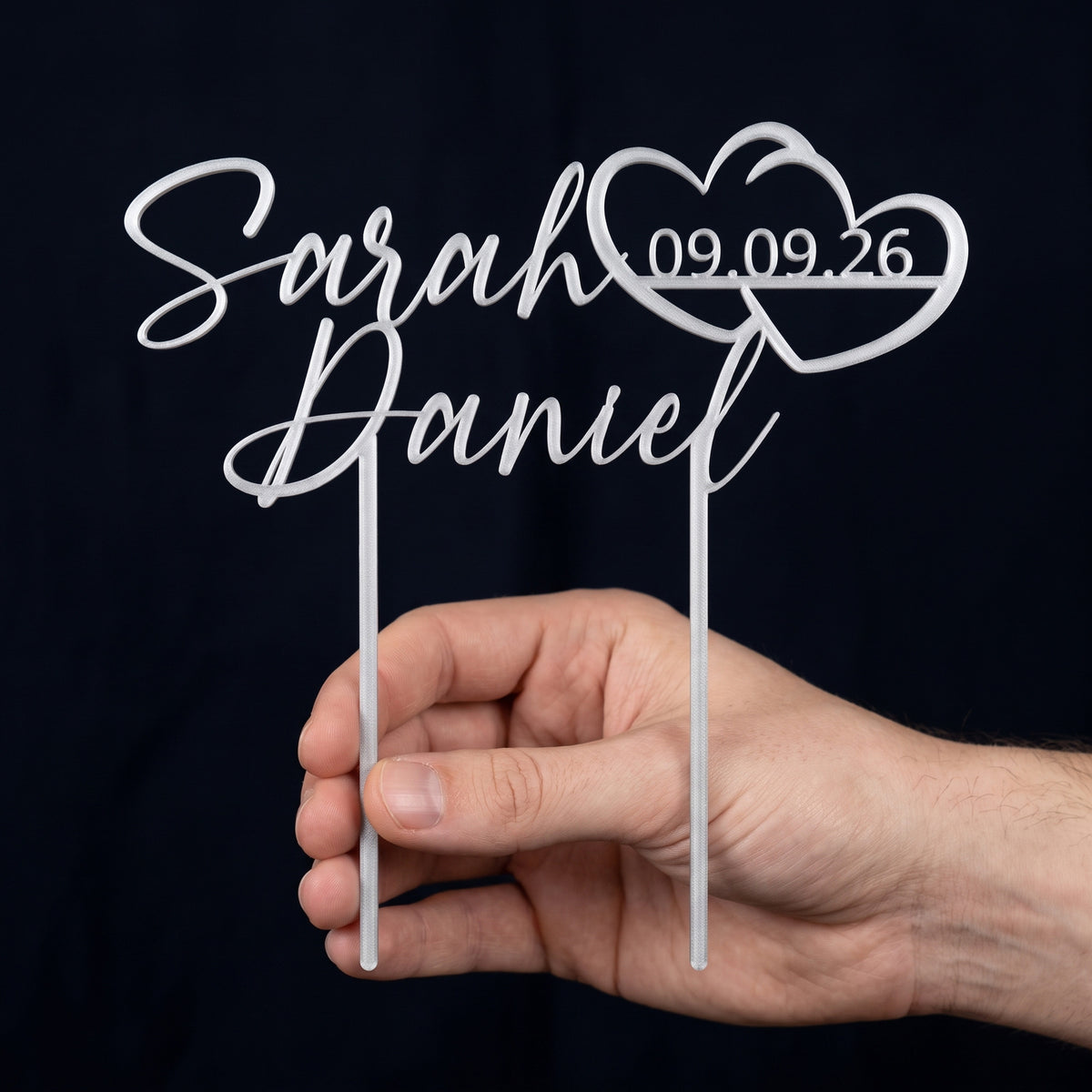 Cake Topper Namen mit Doppelherz in Silber in der Hand