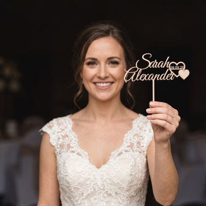 Cake Topper Hochzeit Namen mit Herzpaar in Champagner, von der Braut gehalten