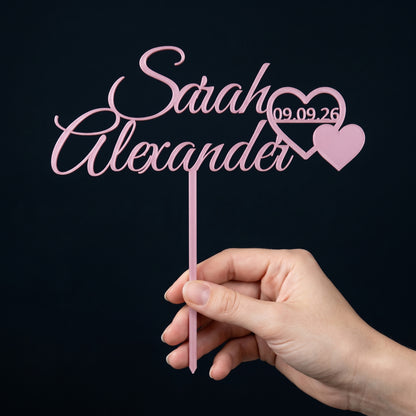 Cake Topper Hochzeit Namen mit Herzpaar in Rosa in der Hand