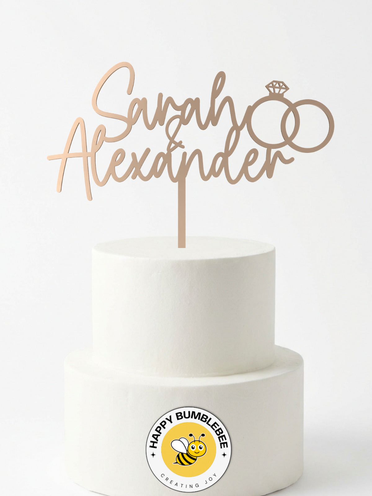 Cake Topper Namen mit Eheringen in Rosegold auf weisser Hochzeitstorte